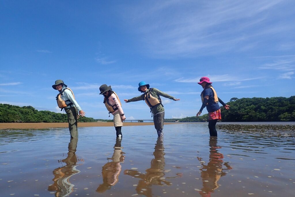 four people are standing on beach