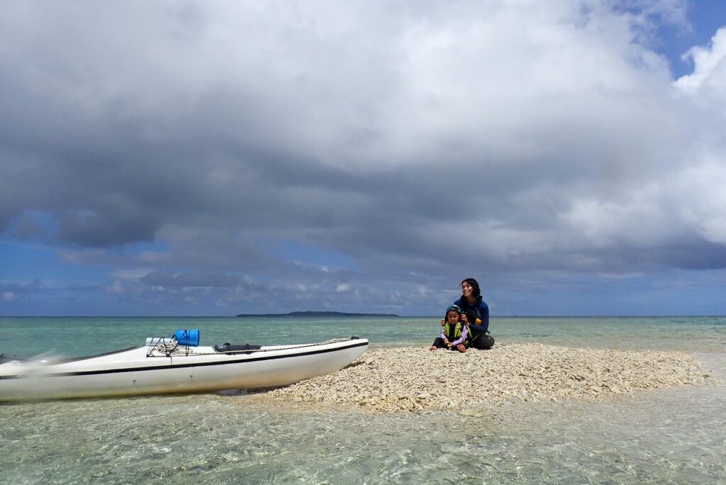 two people are sitting on beach