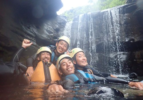 people swiming in waterfall